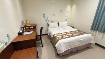 A hotel room with a bed, a desk, and a chair.