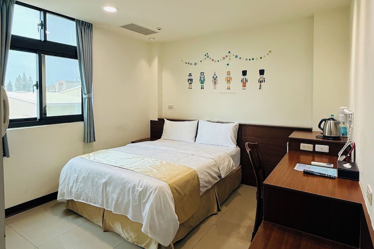 Ein Hotelzimmer mit einem Bett, einem Schreibtisch und einem an der Wand hängenden Kunstwerk.