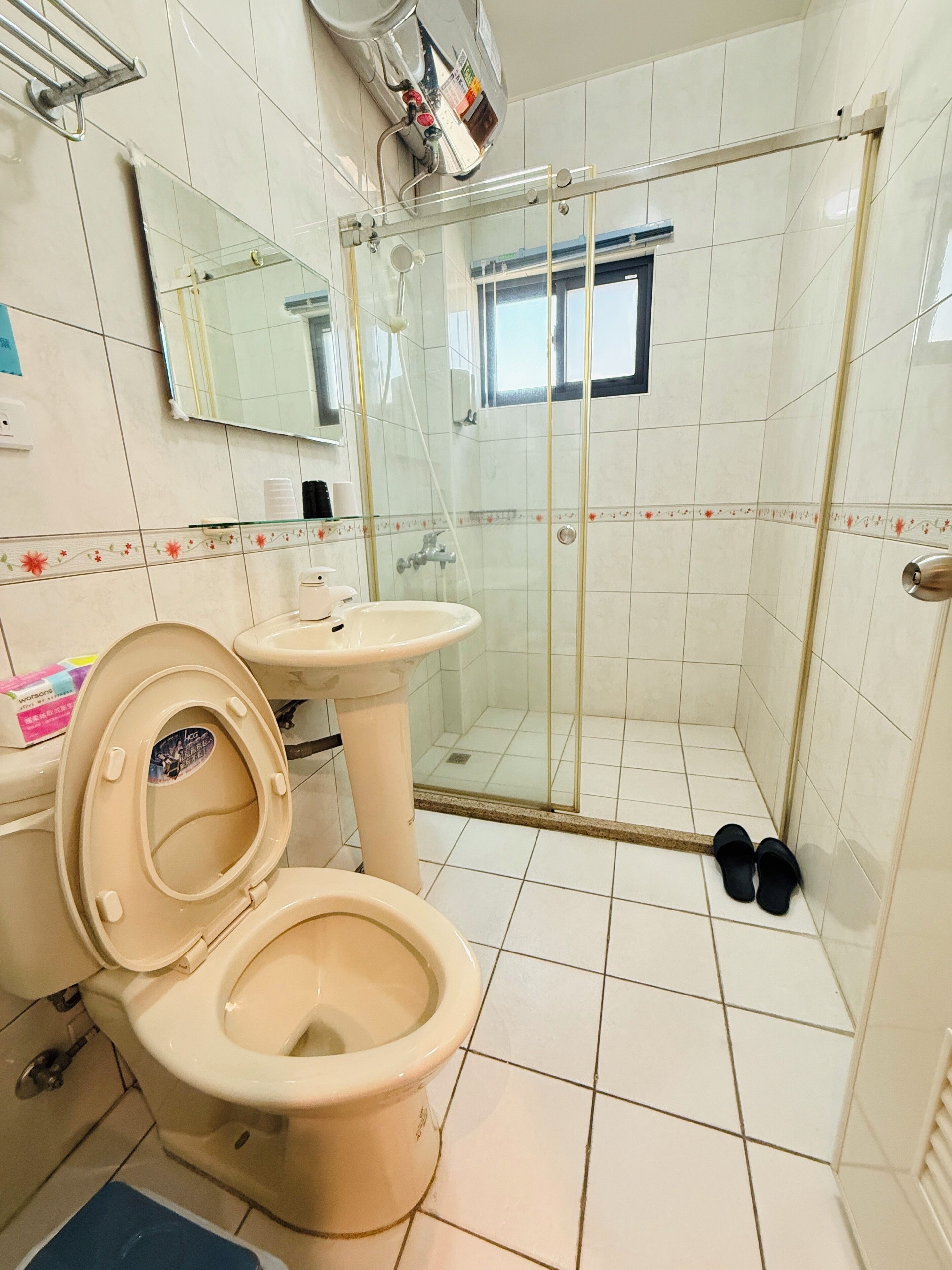 A bathroom with a toilet, sink, and glass-enclosed shower.