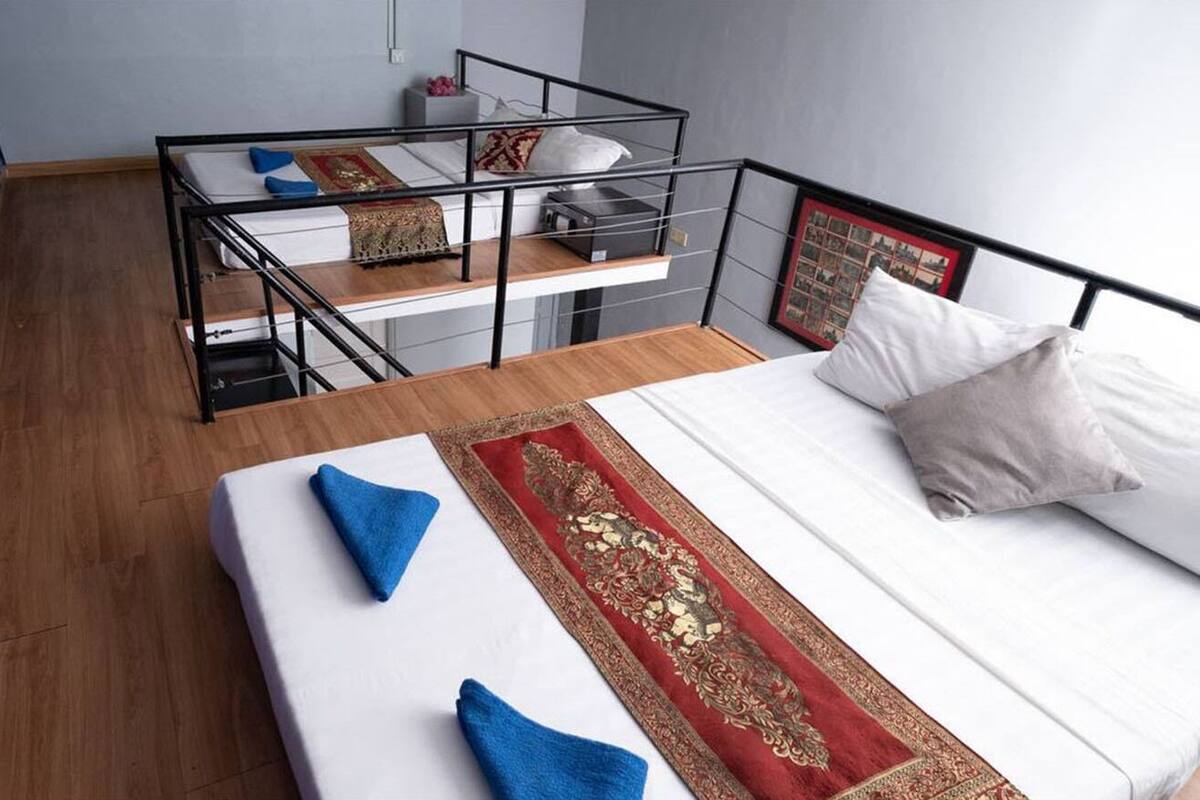 Ein Schlafsaalzimmer mit Etagenbetten, einem Einzelbett und Holzboden.