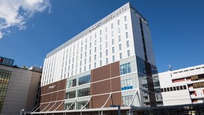 Ein modernes Hotelgebäude mit einem gut sichtbaren Schriftzug 'Shapov Hotel', großen Fenstern und einer strukturierten Fassade.