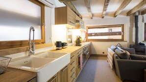 A compact kitchen with a sink, stove, and a window overlooking a scenic view.