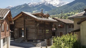A traditional wooden building with a stone foundation, a sloped roof, and a visible chimney.