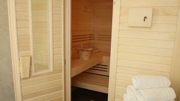 A small, open closet with wooden shelves and a towel rack.