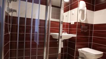 Une salle de bain moderne avec une douche à parois de verre, un lavabo blanc et des toilettes.