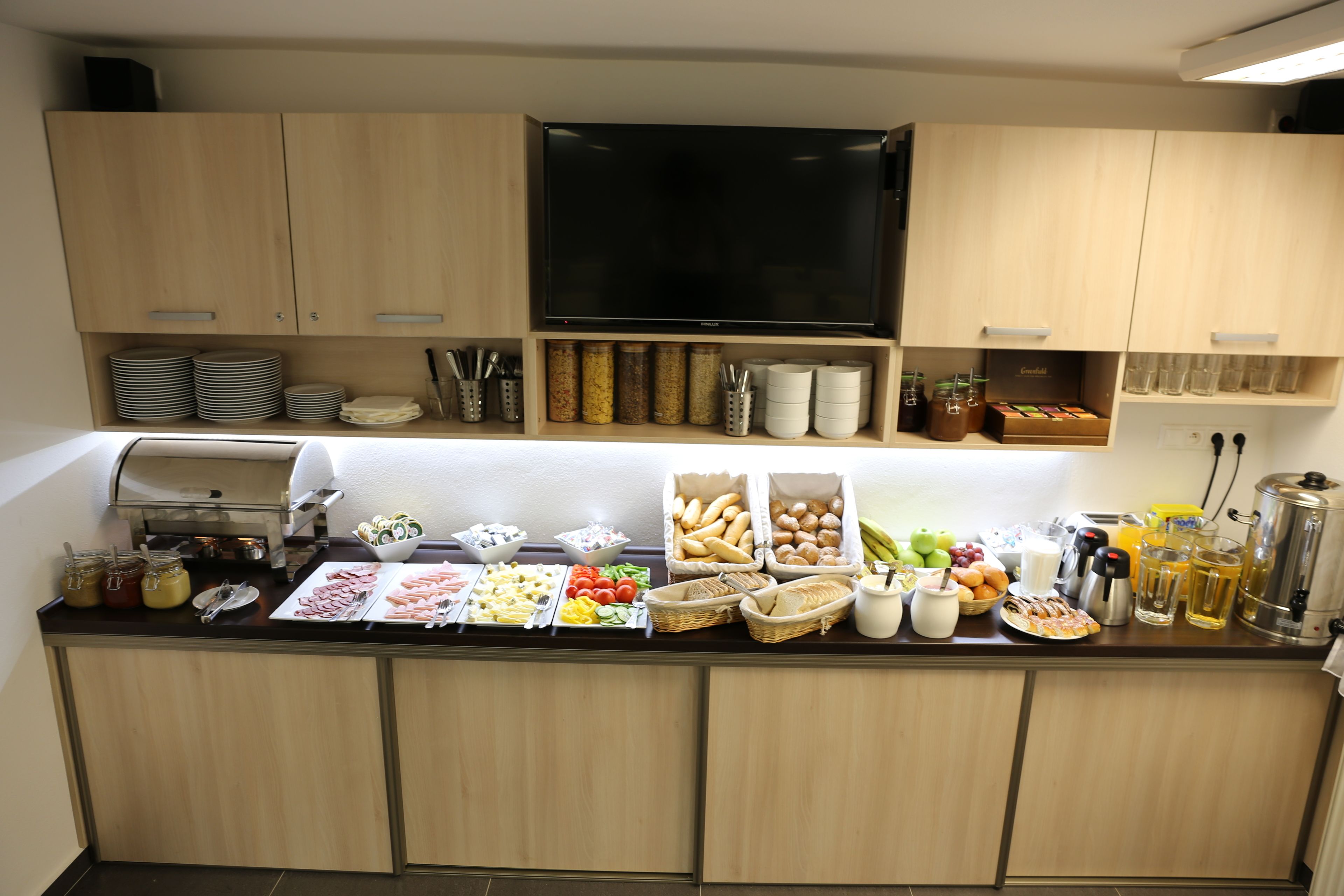 A buffet setup with various food items and condiments.