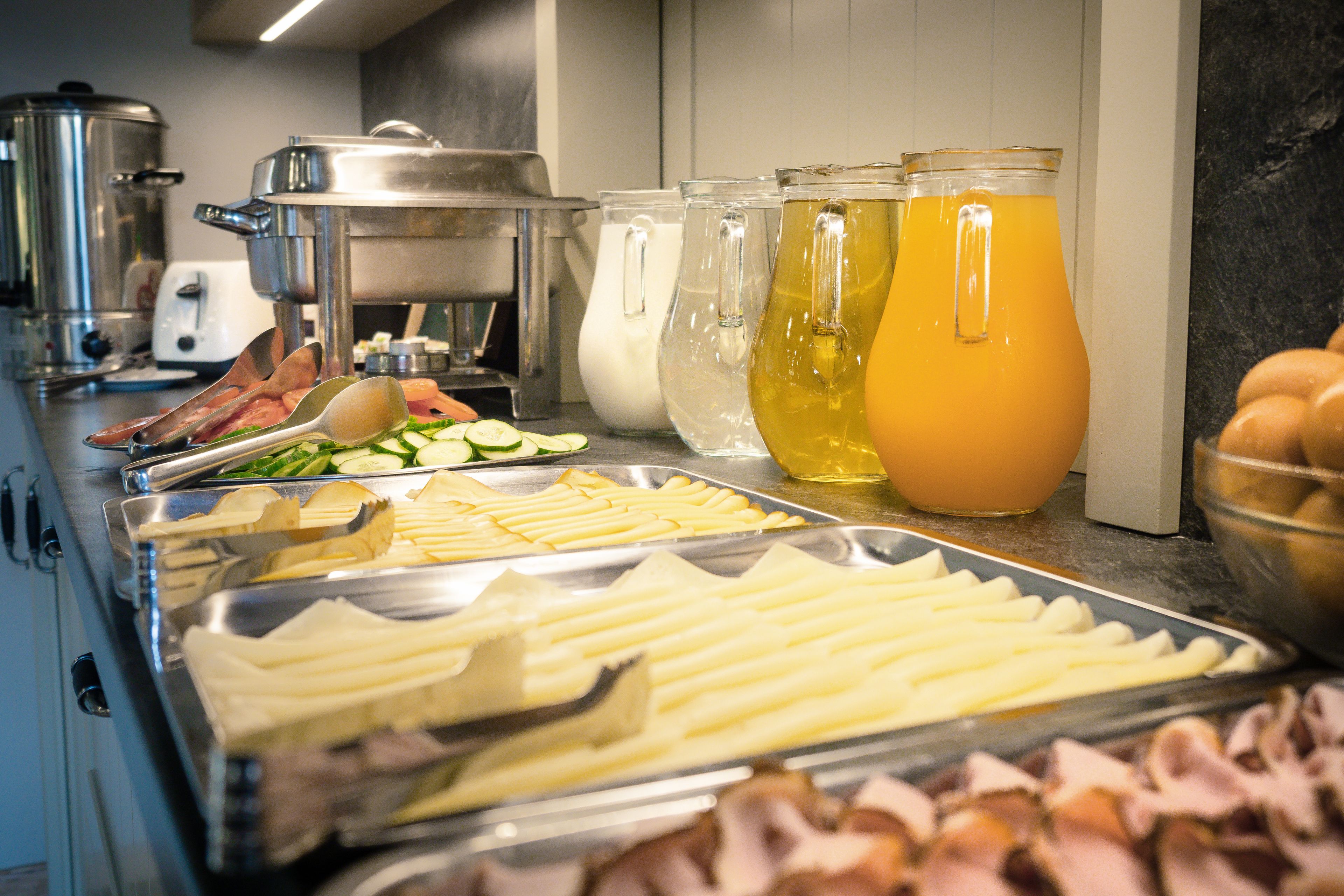 A buffet with various food items and beverages.