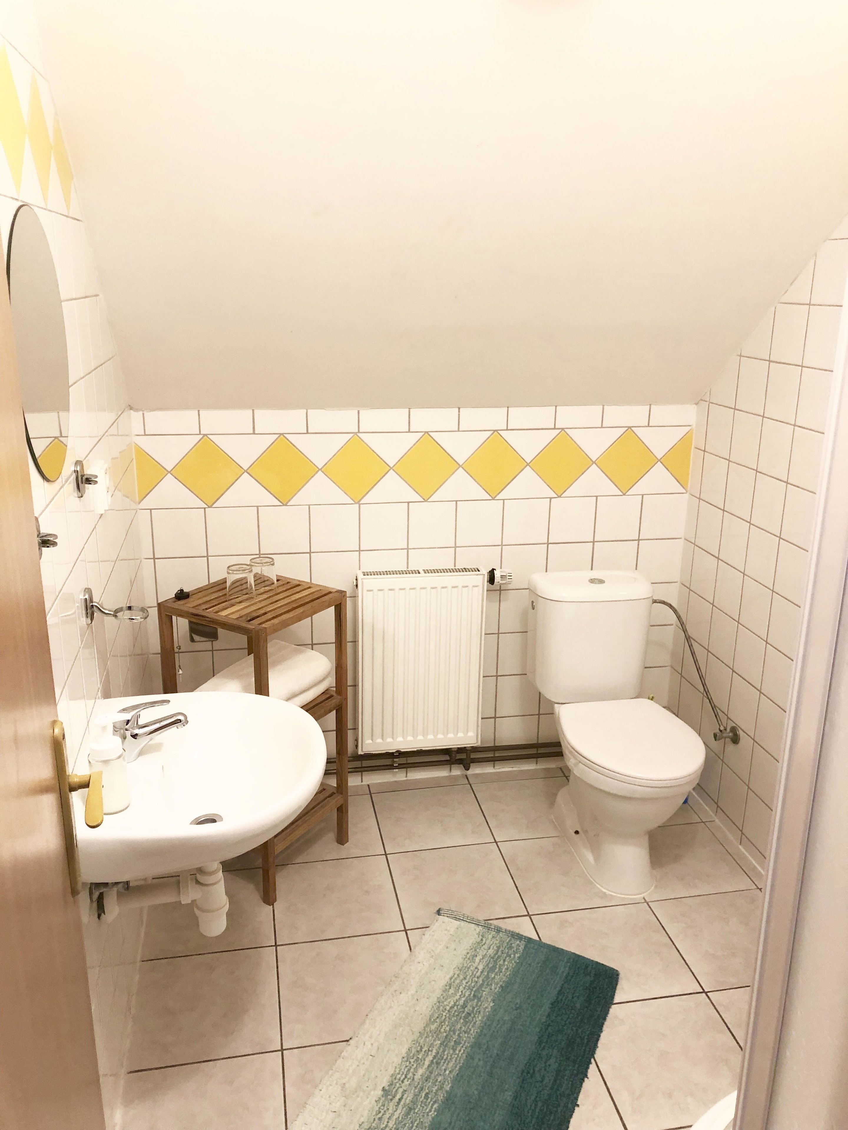 Ein Badezimmer mit Waschbecken, Toilette und Heizkörper.