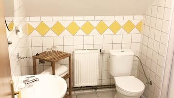 Ein Badezimmer mit Waschbecken, Toilette und Heizkörper.