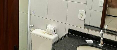 Une salle de bain avec des toilettes, un lavabo et un miroir.
