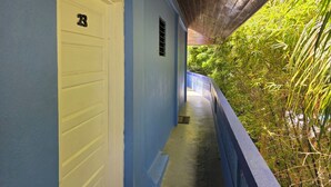 Un pasillo con una pared azul, una puerta blanca y una lámpara en el techo.