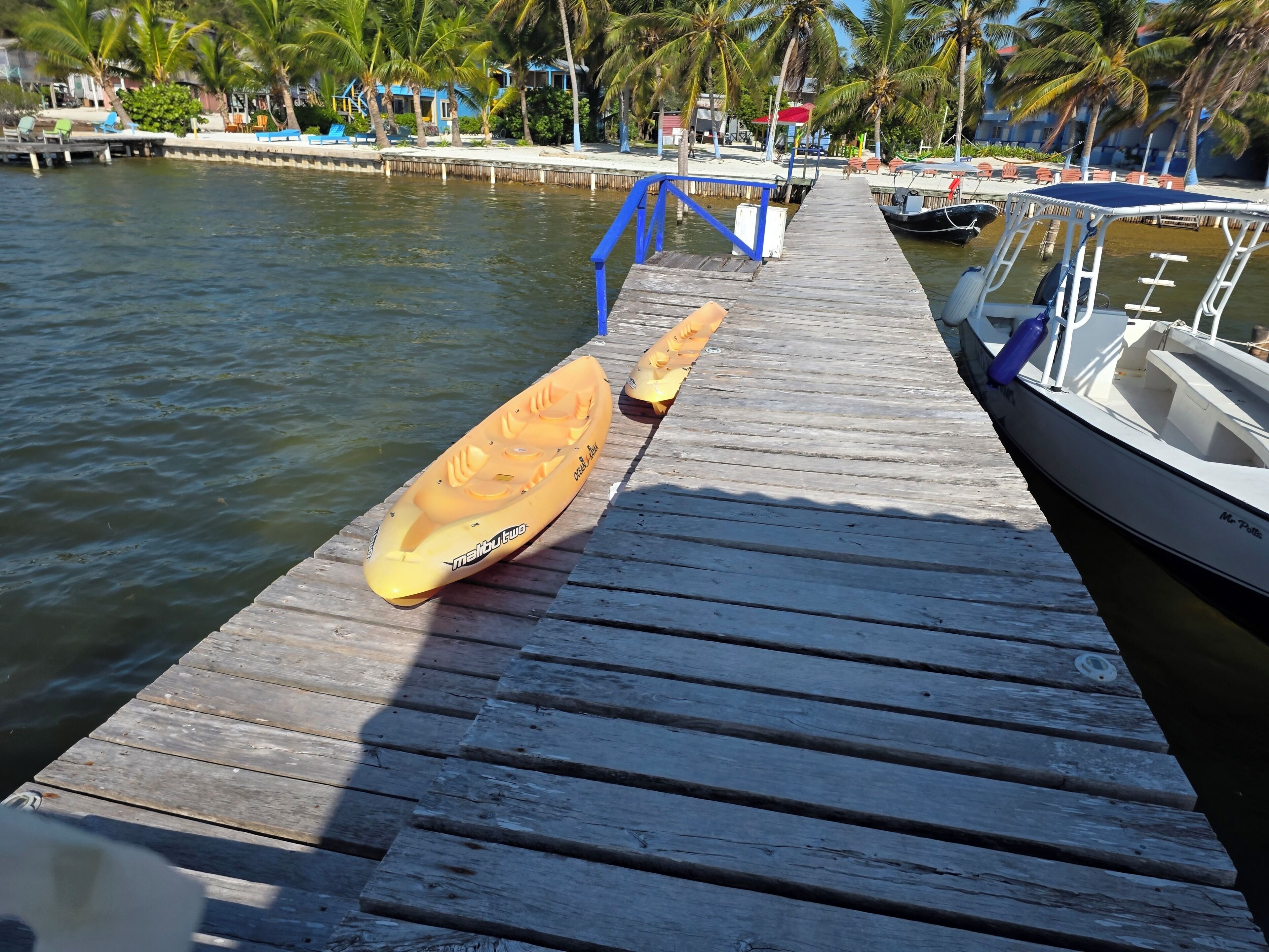 A wooden dock with a kayak and a boat.