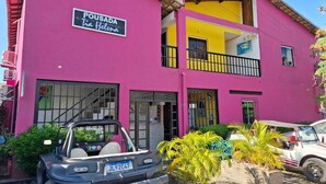 A two-story building with a sign reading "POUSADA Tim Helena".
