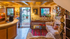 A cozy interior with a reception desk, seating area, and decorative elements. - Hotel Santo Stefano (Venice)