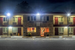 A multi-story hotel with a central entrance, multiple balconies, and a vending machine. - Red Roof Inn Chicago - Alsip (Alsip)