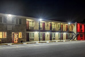 Un hôtel à plusieurs étages, avec une entrée au rez-de-chaussée, de nombreuses fenêtres et un escalier menant aux étages supérieurs.