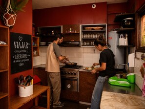 A kitchen with a stove, oven, and a chalkboard with writing. - Estacion Mendoza Hostel (Mendoza)