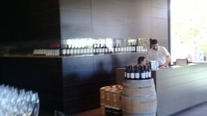 A modern bar area with a counter, wine bottles, and glasses. - Estacion Mendoza Hostel (Mendoza)