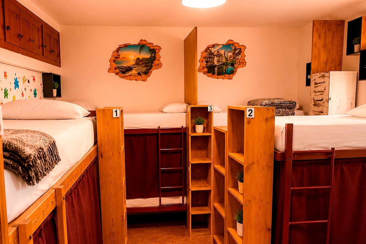 Une chambre de dortoir avec des lits superposés, des étagères en bois et un ventilateur de plafond.