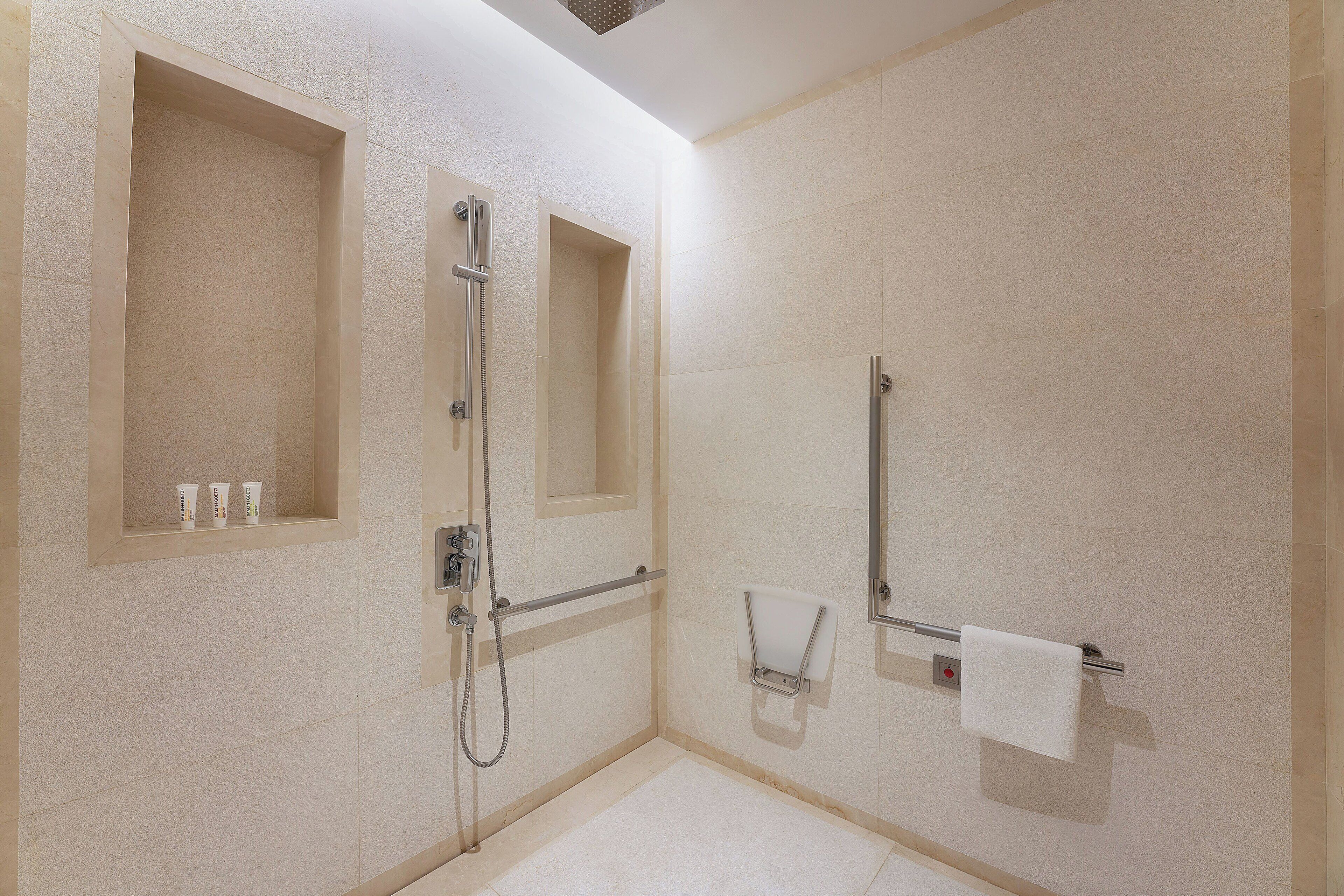 A modern bathroom with a shower, a toilet, and a sink.
