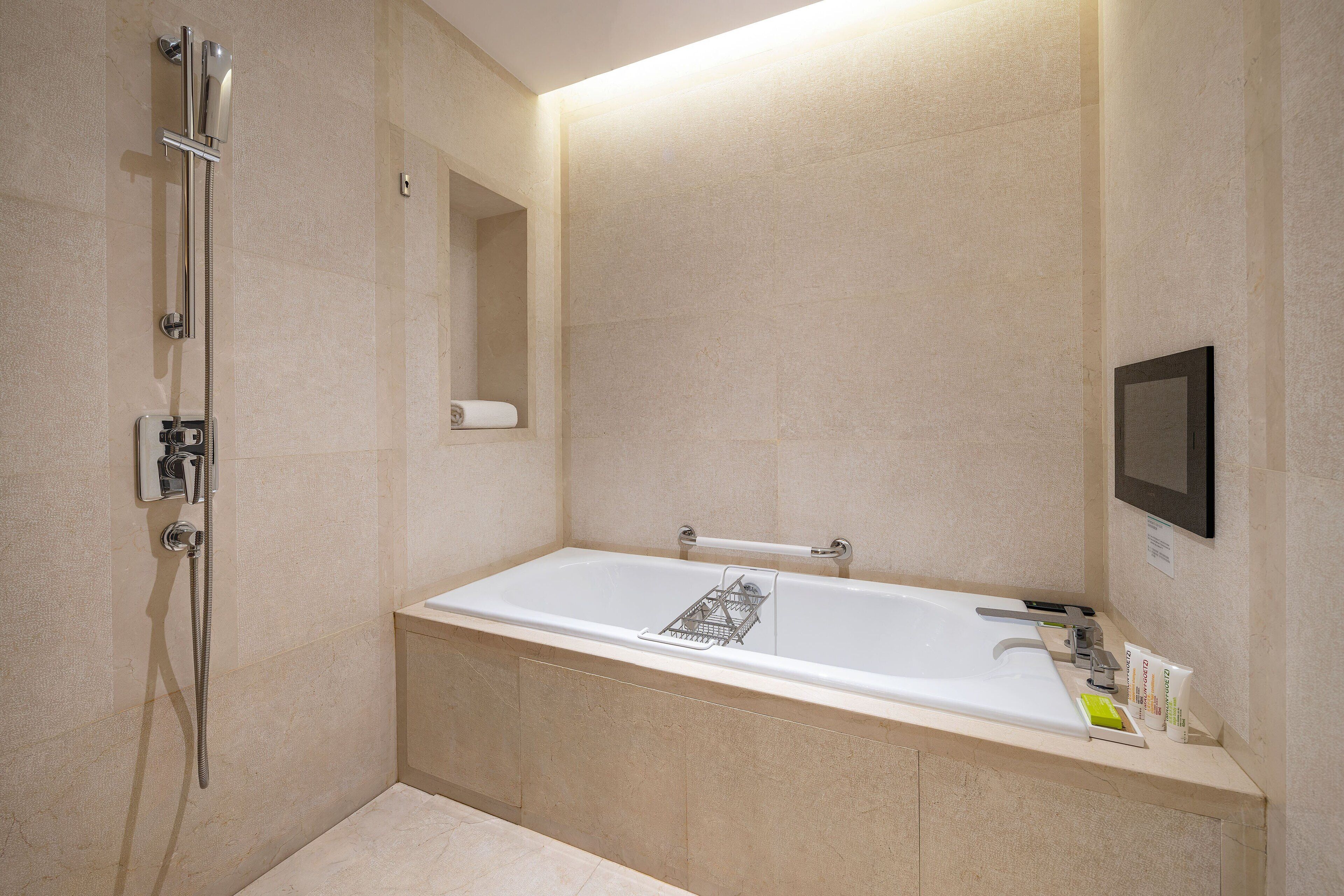 A modern bathroom with a bathtub, a shower, and a toilet.