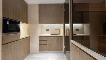 Una cocina moderna con armarios de madera, un microondas integrado y un lavamanos de acero inoxidable.