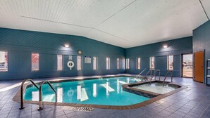 An indoor swimming pool with a diving area, tiled floor, and a clock on the wall. - Quality Inn New London (New London)