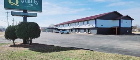 Un hôtel Quality Inn, appartenant au groupe Choice Hotels, doté d’un parking, d’une zone de stationnement couverte et d’un bâtiment avec un toit rouge.