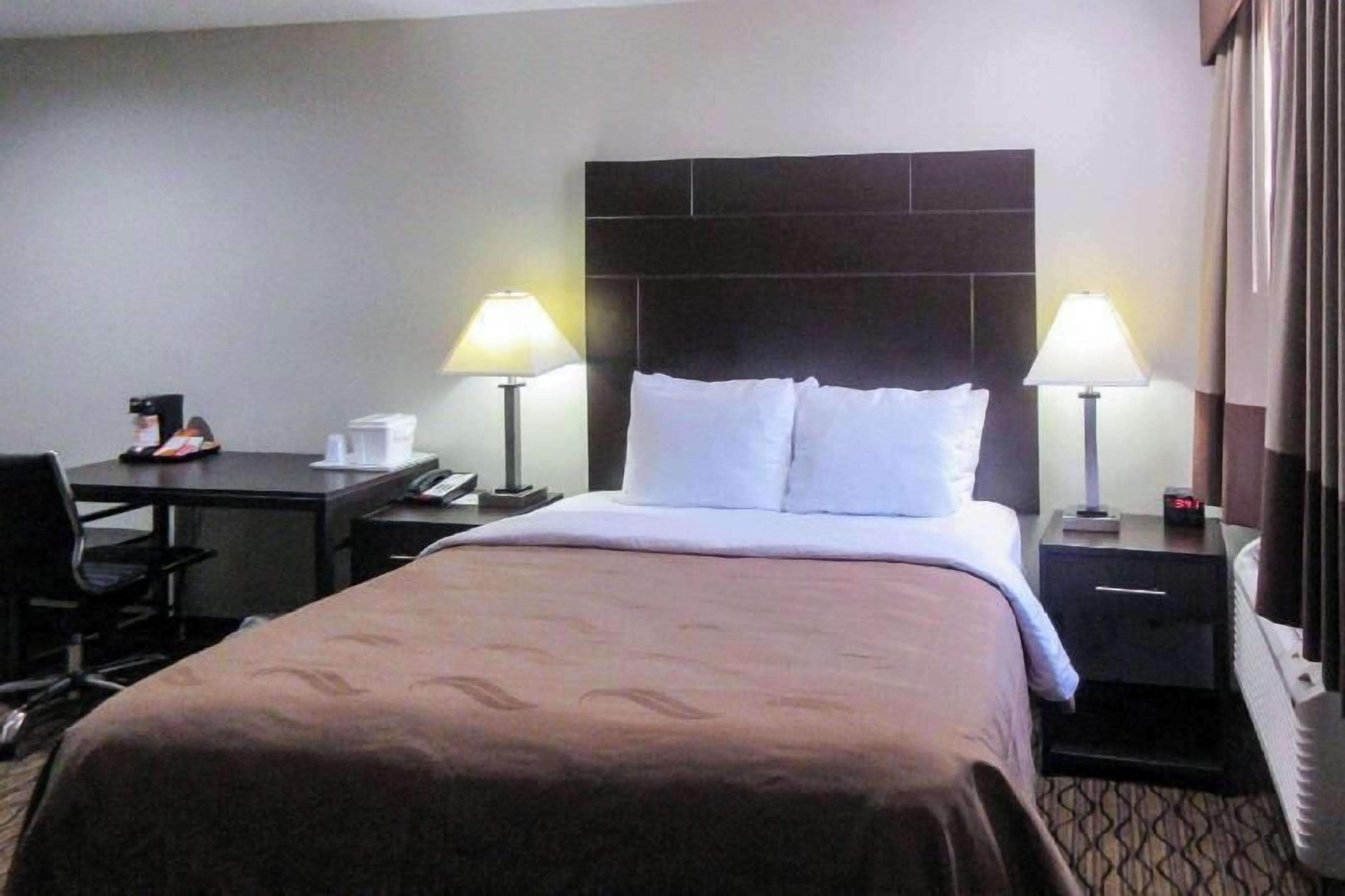 Premium bedding, desk, laptop workspace, blackout drapes