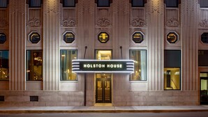 Un edificio con un cartel luminoso que dice 'HOLSTON HOUSE' sobre la entrada.