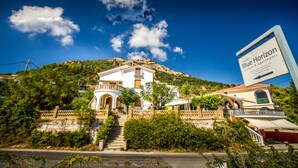A two-story building with a balcony and a staircase leading to the entrance. - Blue Horizon Studios (Zakynthos)