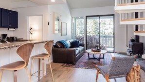 A modern living space with a kitchen, a sofa, and a dining area. - Crestview B44 (Mammoth Lakes)