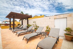 Una piscina al aire libre, sillones reclinables de piscina