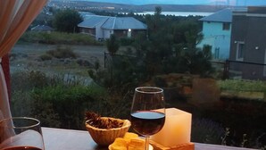 Une table avec deux assiettes de nourriture et deux verres de vin rouge, le tout placé devant un paysage pittoresque.