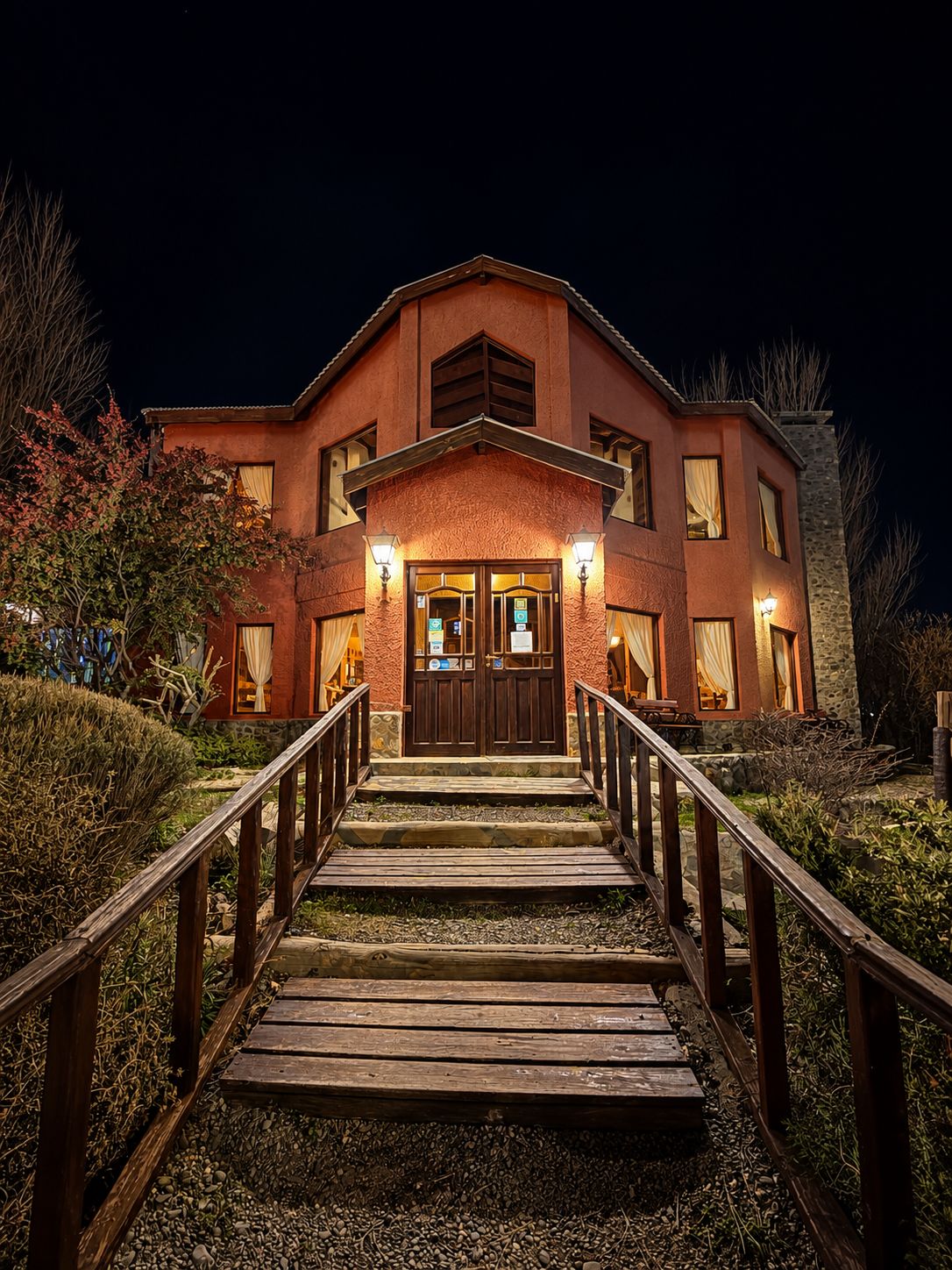 A two-story building with a wooden staircase leading to a set of double doors.