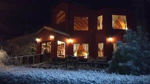 Un bâtiment à deux étages, doté de nombreuses fenêtres illuminées et d’une entrée bien visible.