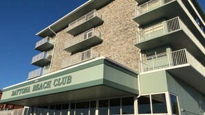 Un immeuble à plusieurs étages doté de balcons, d’une façade en pierre et d’une enseigne indiquant « Daytona Beach Club ».