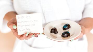 Una persona sosteniendo un plato con tres trufas de chocolate y una tarjeta con un mensaje.