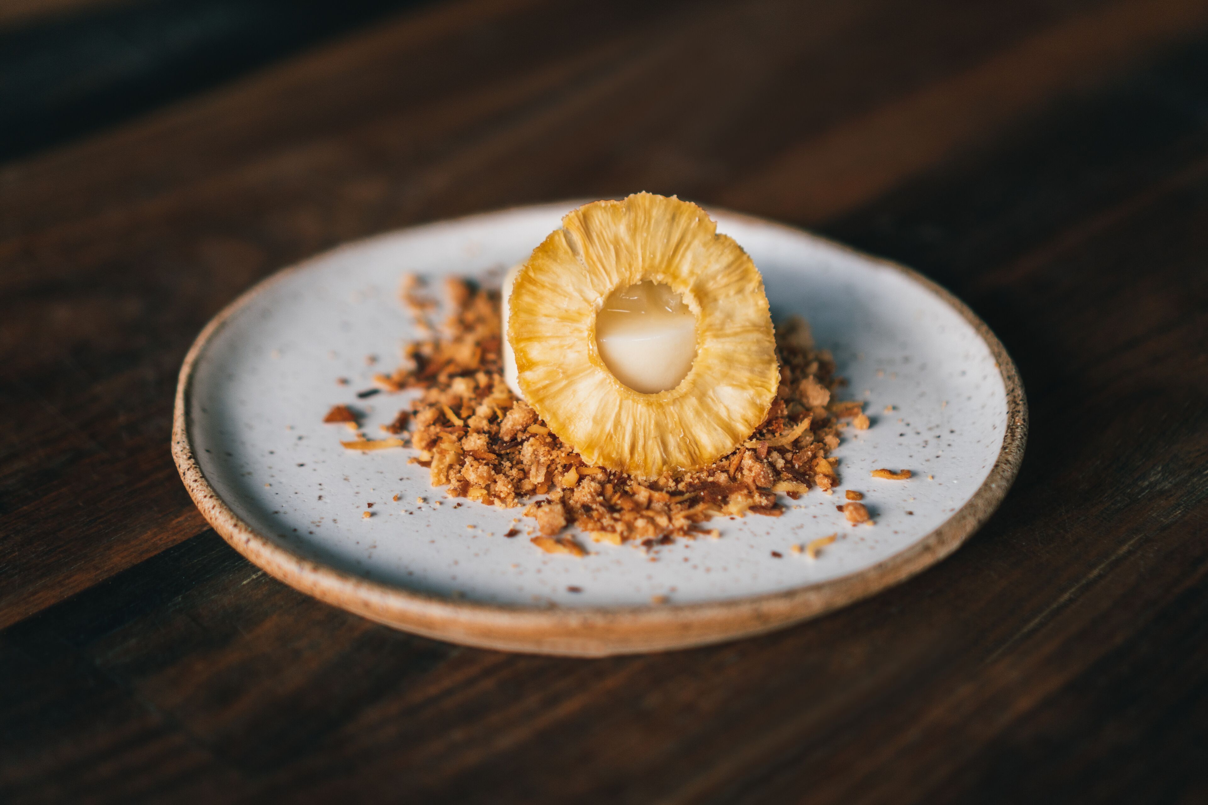 A dessert on a ceramic plate with a wooden background.