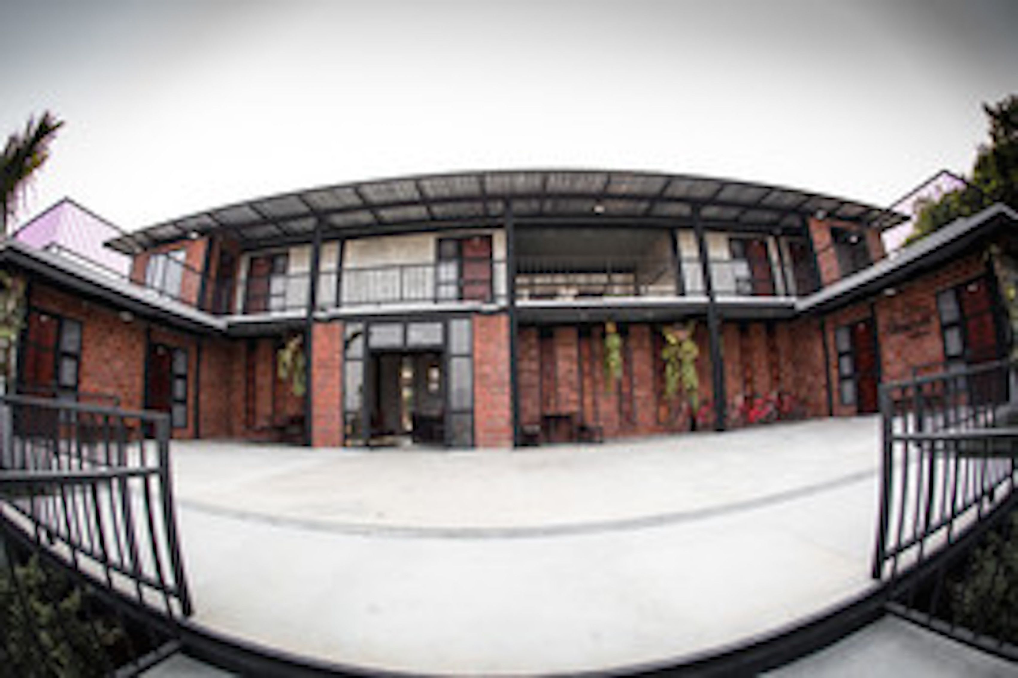 A modern building with a curved roof and brick facade.