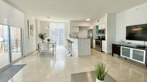 A modern apartment with a kitchen, dining area, and living room.