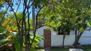 Un chemin de pierres mène à un bâtiment blanc doté d’une porte en bois.