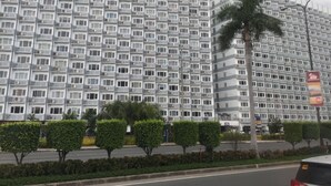 A high-rise building with a repetitive facade pattern, featuring balconies and air conditioning units. - Best Value 5-Star QCondo across Mall of Asia, near Airport, Casinos & Manila Bay (Pasay)