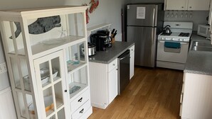 A kitchen with white cabinets, a stainless steel refrigerator, a stove, and a microwave. - Ocean View Home With Large Yard, A/c, Hot Tub, Walk To Sandy Beach, Pets Ok (Narragansett)