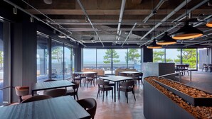 A modern restaurant with large windows, tables, and chairs arranged for dining. - ONCRI-KARATSU (Karatsu)
