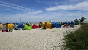 A beach with colorful beach huts and tents, a sandy shore, and a clear sky. - Spacious vacation residence for 6 pers. with pool and garden. Sauna - shared use (Stadland-Reitland)