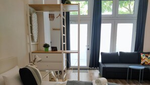 Un dormitorio moderno con cama, escritorio, silla, sofá y una mesita.