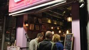 A restaurant with a neon sign and a menu board outside. - Ukkei Inn (Kowloon)