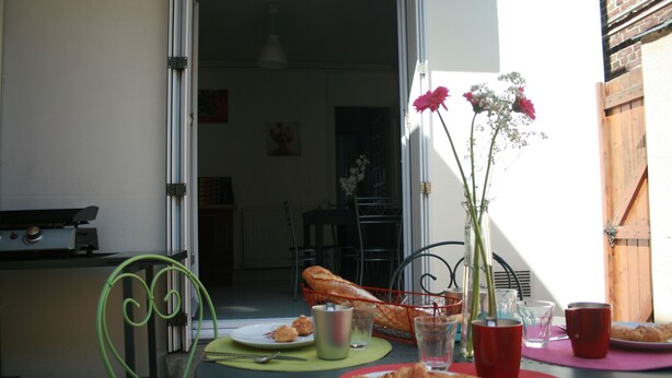 Una mesa de comedor con platos, tazas y un florero.
