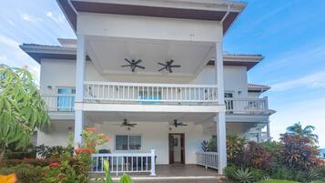 A two-story building with a balcony, a covered patio, and a front door.